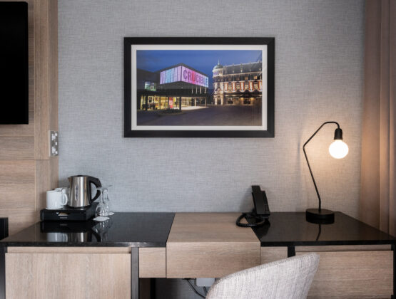 A well-furnished hotel room with a desk, chair, and television, ideal for work and relaxation.