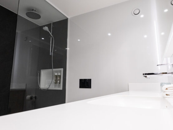 A modern bathroom featuring a glass shower stall and a sleek sink, showcasing a clean and minimalist design.