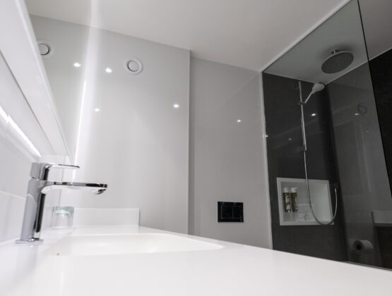 A sleek modern bathroom featuring a glass shower stall and contemporary fixtures.