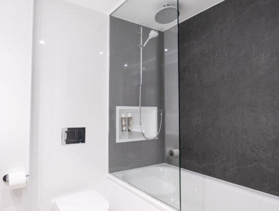 A sleek modern bathroom featuring a glass shower door and contemporary fixtures.