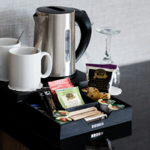 Thumbnail of http://A%20tray%20containing%20complimentary%20coffee,%20tea,%20and%20snacks.%20Set%20up%20on%20the%20twin%20bedroom%20desk%20area,%20with%20a%20kettle%20and%20wine%20glasses.