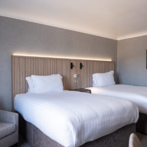Thumbnail of http://Two%20beds%20in%20a%20hotel%20room%20with%20a%20desk%20and%20chair,%20providing%20a%20comfortable%20and%20functional%20space%20for%20guests