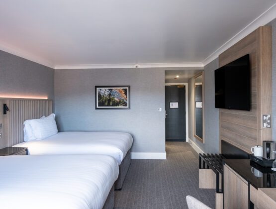 A hotel room featuring two beds and a television, designed for comfort and relaxation.