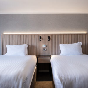 Thumbnail of http://A%20hotel%20room%20featuring%20two%20beds,%20both%20dressed%20in%20crisp%20white%20sheets,%20offering%20a%20comfortable%20sleeping%20arrangement.
